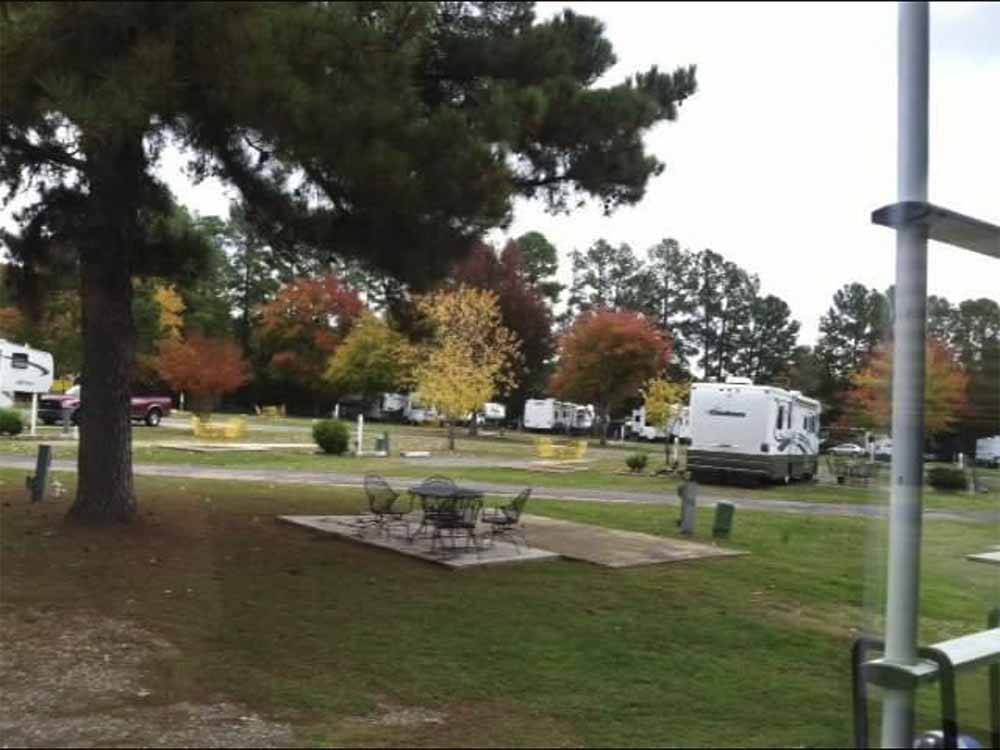 A sitting area next to an RV site at SHREVEPORT/BOSSIER KOA JOURNEY
