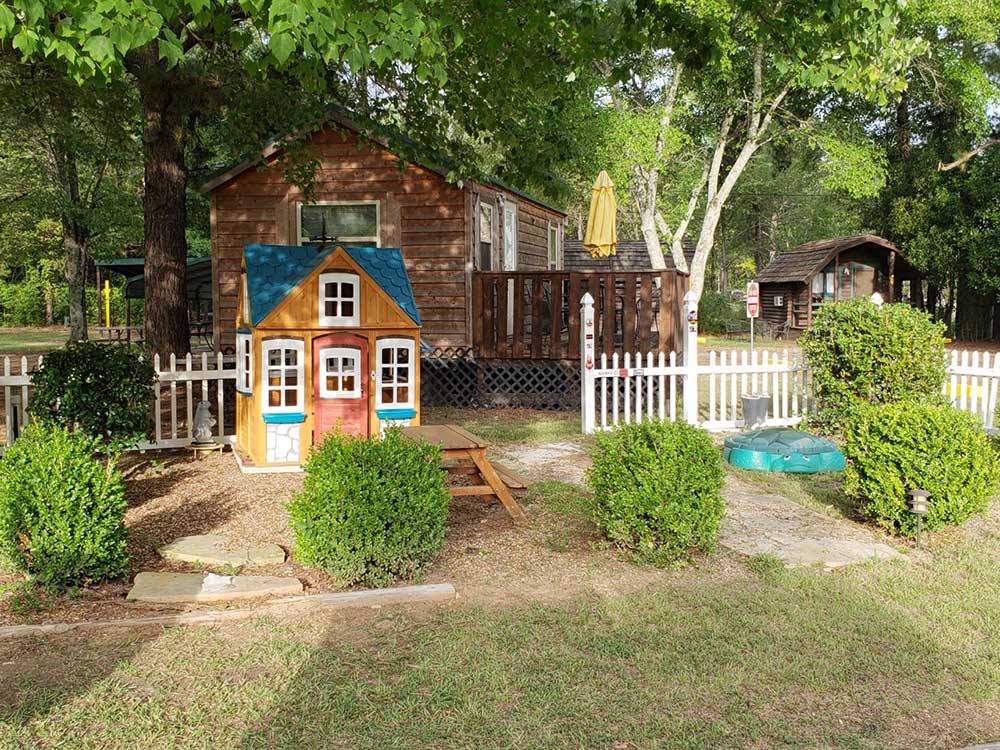 Playhouse and picnic table next to a cabin at SHREVEPORT/BOSSIER KOA JOURNEY