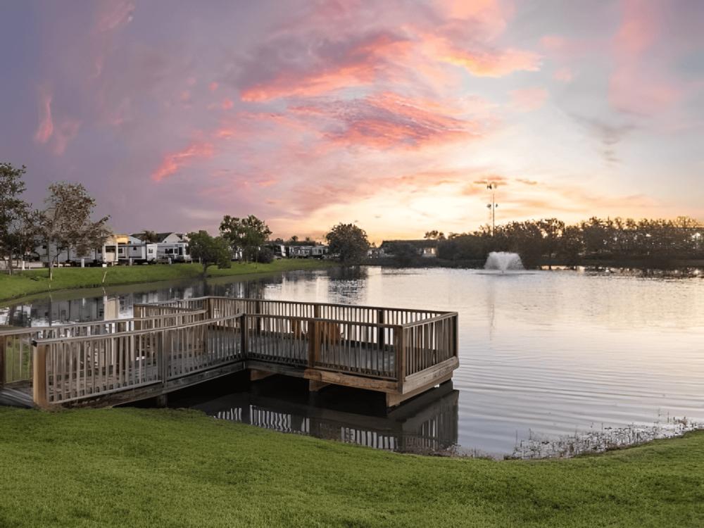 Lake with dock surrounded by green lawn