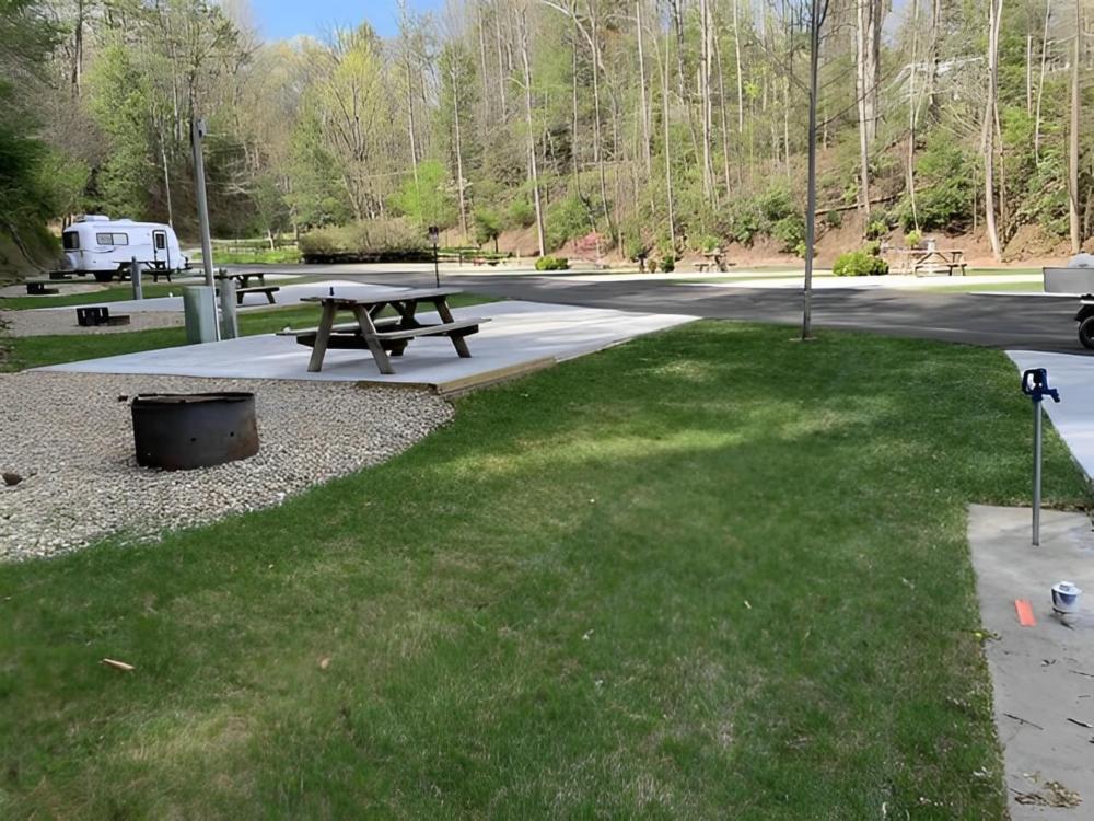 A large RV site with table and fire pit