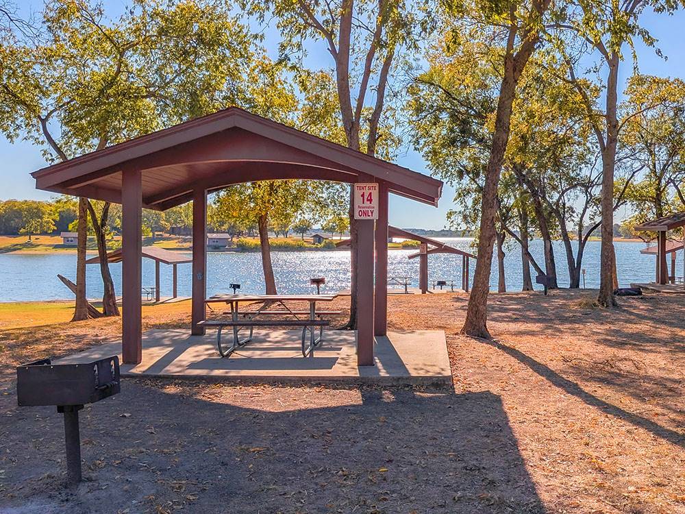 Covered picnic tables by the lake at Hidden Cove Park