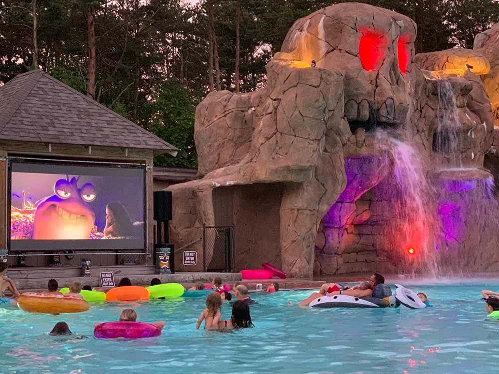 Guest watching a movie from the swimming pool at MOOSE HILLOCK CAMPING RESORT NY