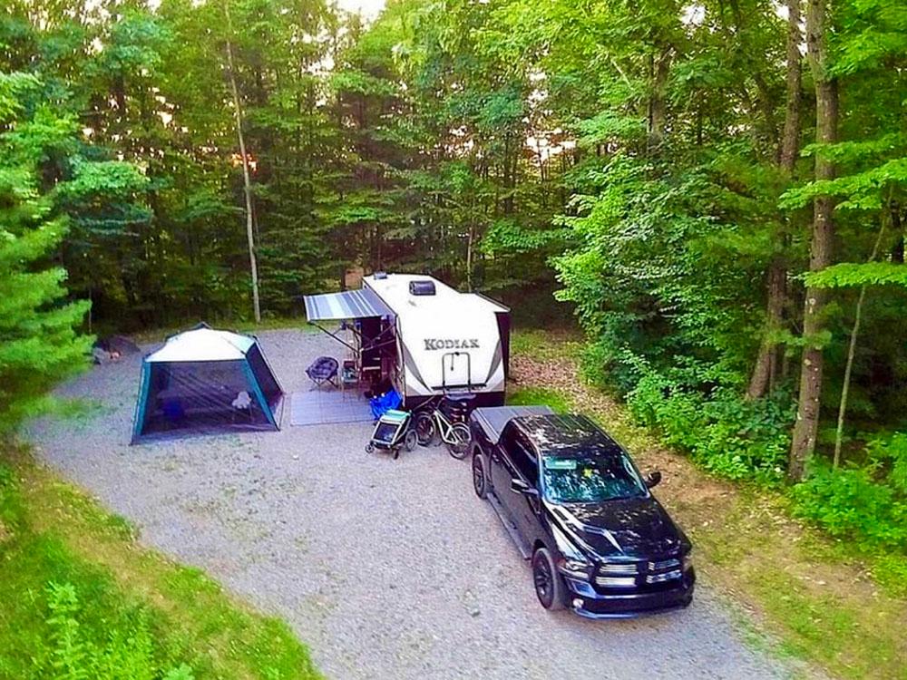 A black truck and trailer backed in at MOOSE HILLOCK CAMPING RESORT NY