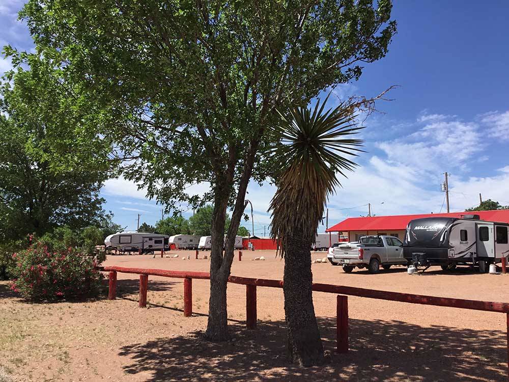 Trees in foreground, main building in distance at WILD WEST RV PARK