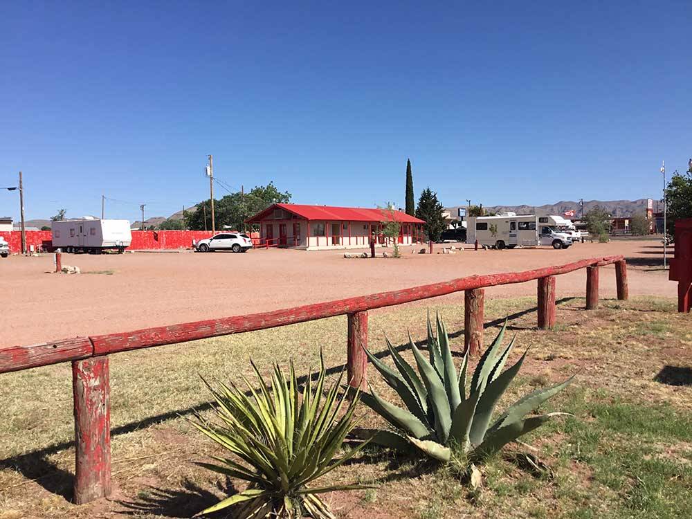 Plants and a wooden fence near main building at WILD WEST RV PARK