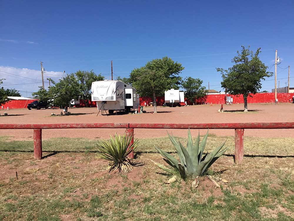 Wooden fence with RVs parked onsite at WILD WEST RV PARK