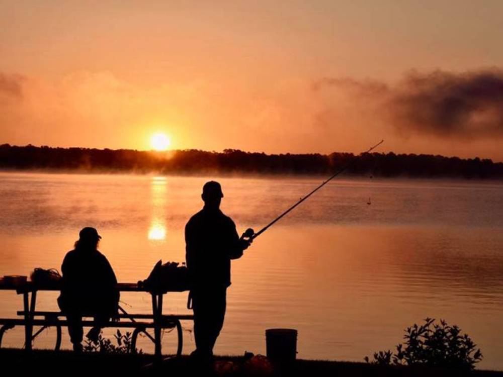 People fishing at the lake at sunset