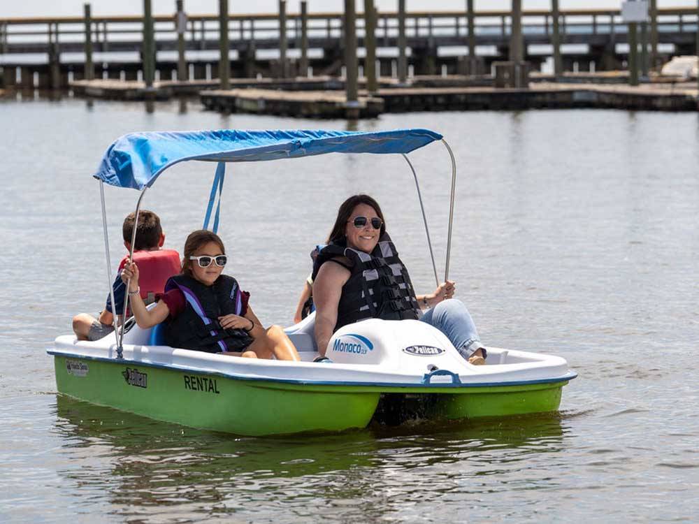 A mother and her kids in a paddle boat at PALMETTO SHORES RV RESORT