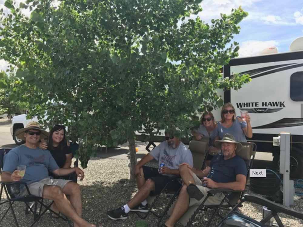 A group of people sitting outside of a trailer at NEW FRONTIER RV PARK