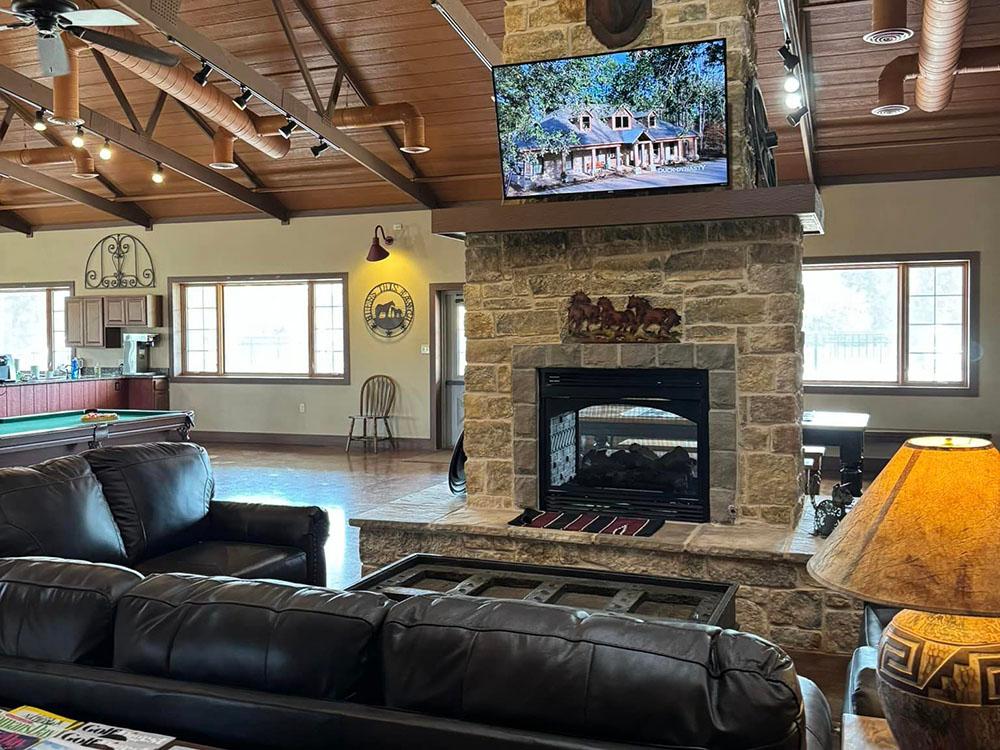 Sofa in front of a TV and fireplace at THE CAMPGROUND COLLECTIVE