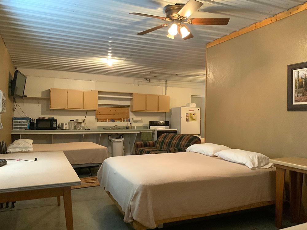 Beds and kitchen area in a rental cabin at D & S CAMPGROUND & LODGE