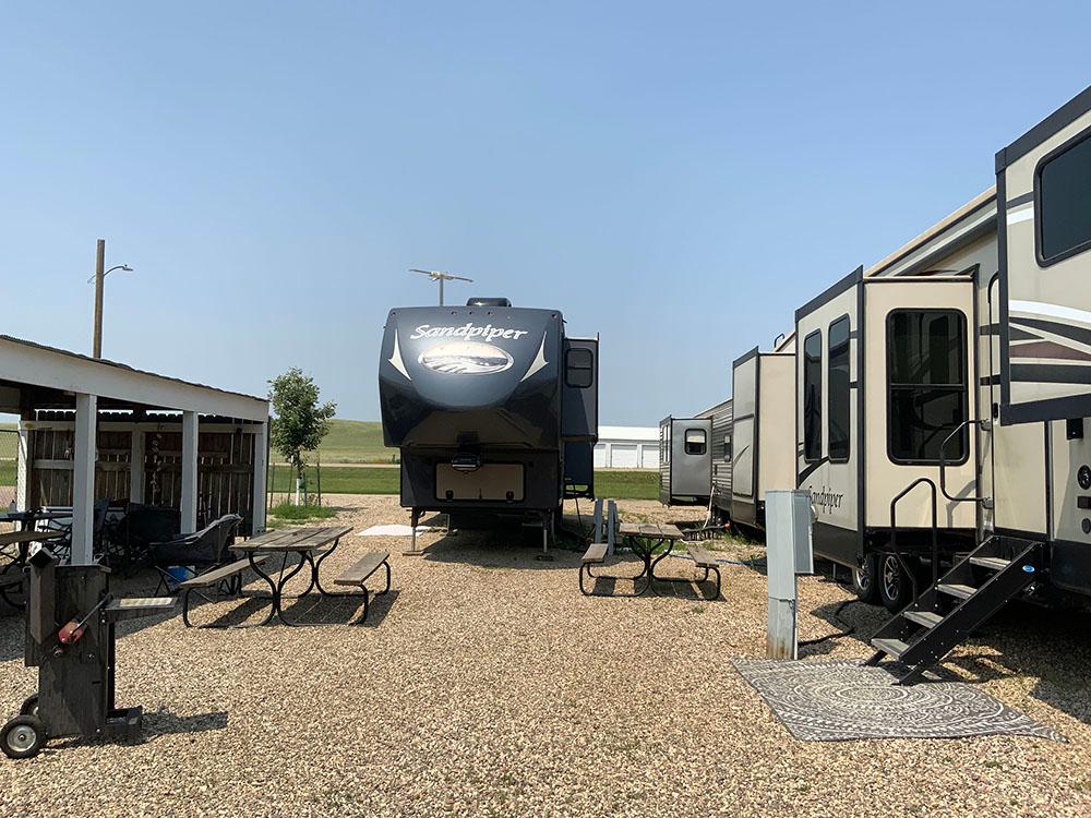 RVs in gravel sites near a small pavilion at D & S CAMPGROUND & LODGE