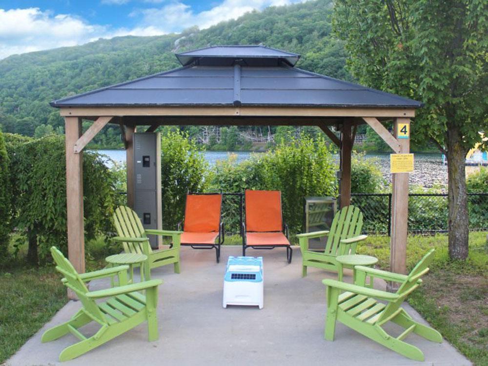 Cabana with chairs by the lake at LAKE COMPOUNCE CAMPGROUND