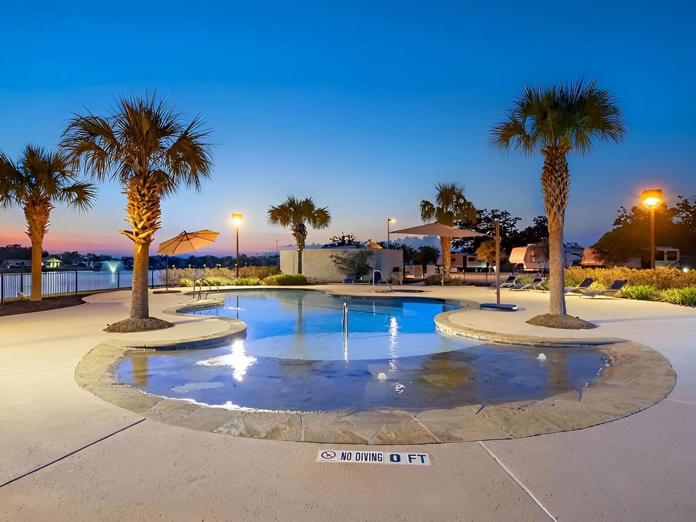 The pool and palm trees at Brazoria Lakes RV Resort