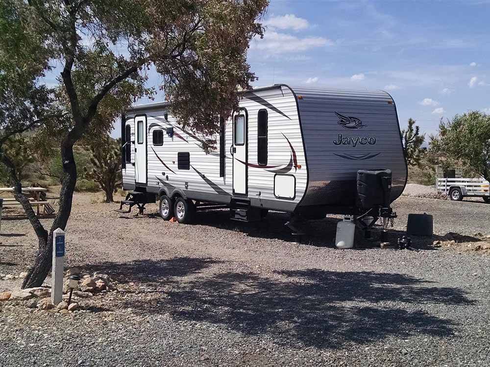 A travel trailer in a gravel RV site at MEADVIEW RV PARK & COZY CABINS