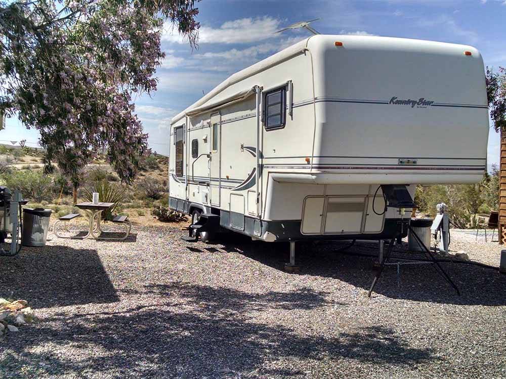 A fifth wheel trailer in a gravel RV site at MEADVIEW RV PARK & COZY CABINS