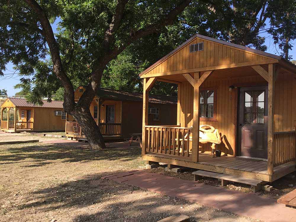 A row of rustic rental cabins at TREE CABINS RV RESORT