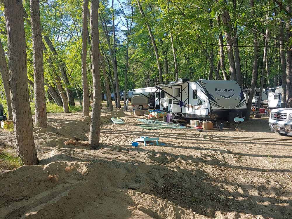 A group of RVs under trees at BEACH CAMPING AREA