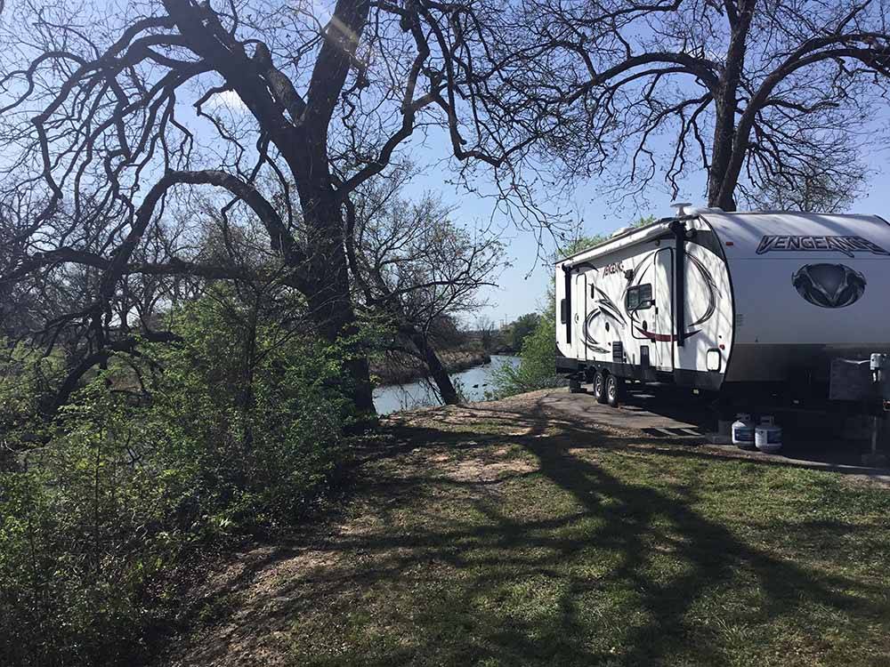 An RV site by the water at RIVERSIDE PARK RV
