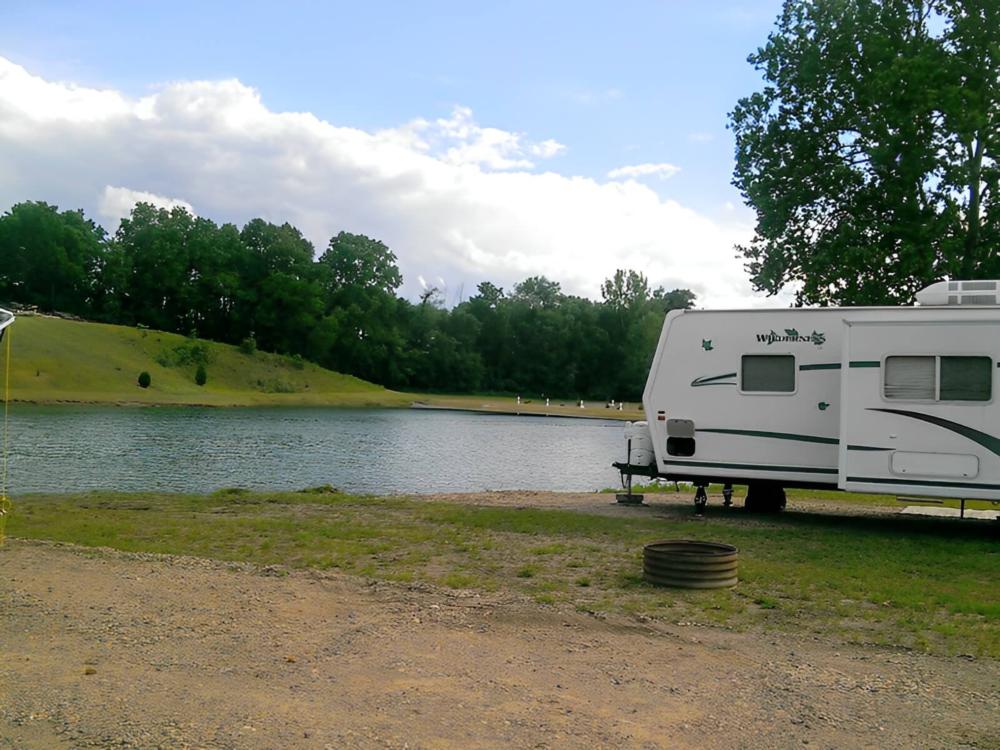 Parked trailer near lake at site Harbor Cove RV Resort
