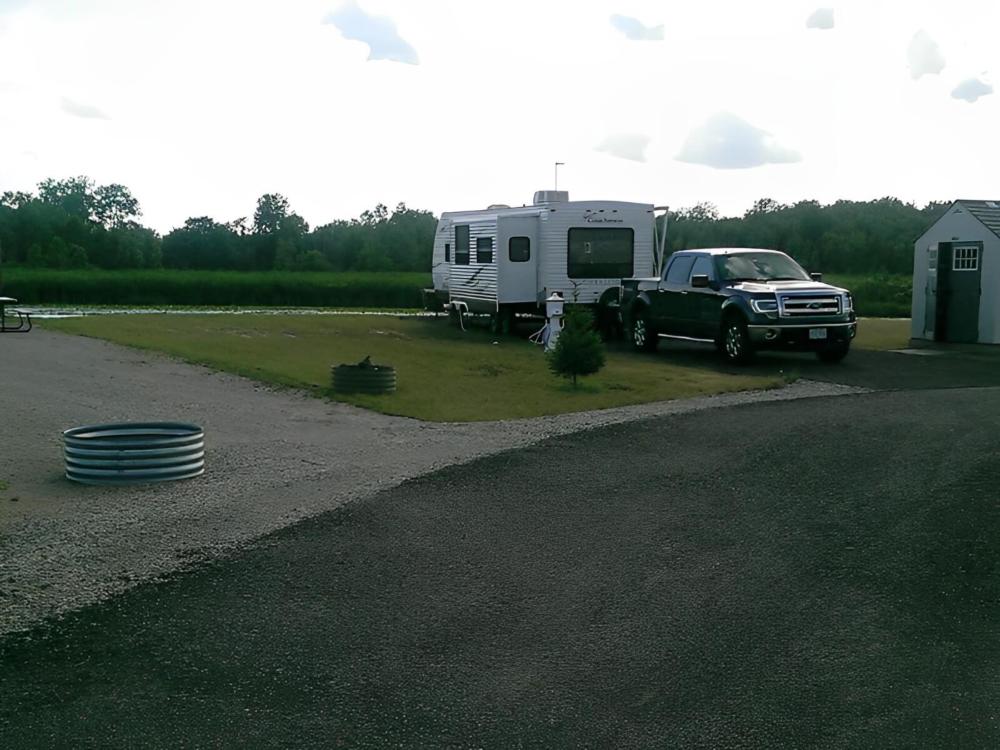 Open RV space next to parked trailer at site Harbor Cove RV Resort