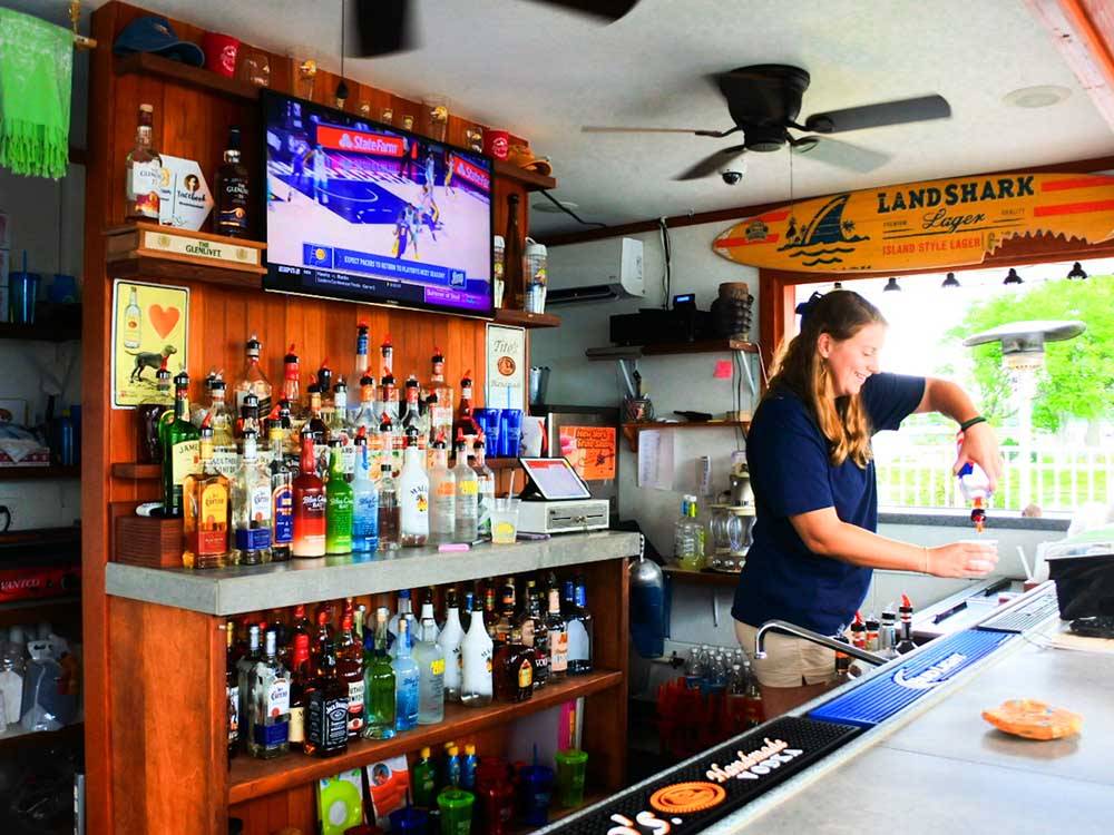 A bartender making a drink at the outside bar at SWAN BAY RESORT