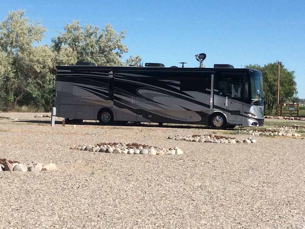 A motorhome in a gravel RV site at WORLAND RV PARK AND CAMPGROUND