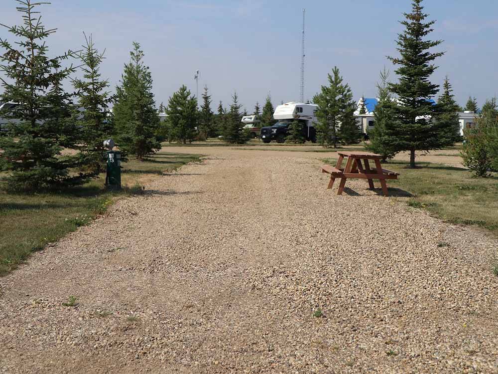 A gravel RV site with a picnic table at RENDEZ VOUS RV PARK & STORAGE