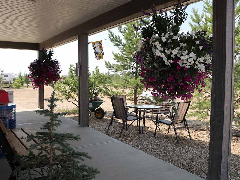 Potted flowers hanging from the porch at RENDEZ VOUS RV PARK & STORAGE