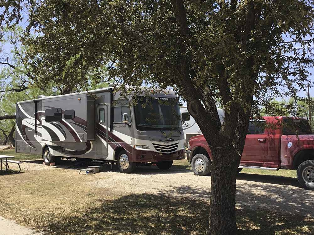 A motorhome next to a tree at CONCHO PEARL RV ESTATES