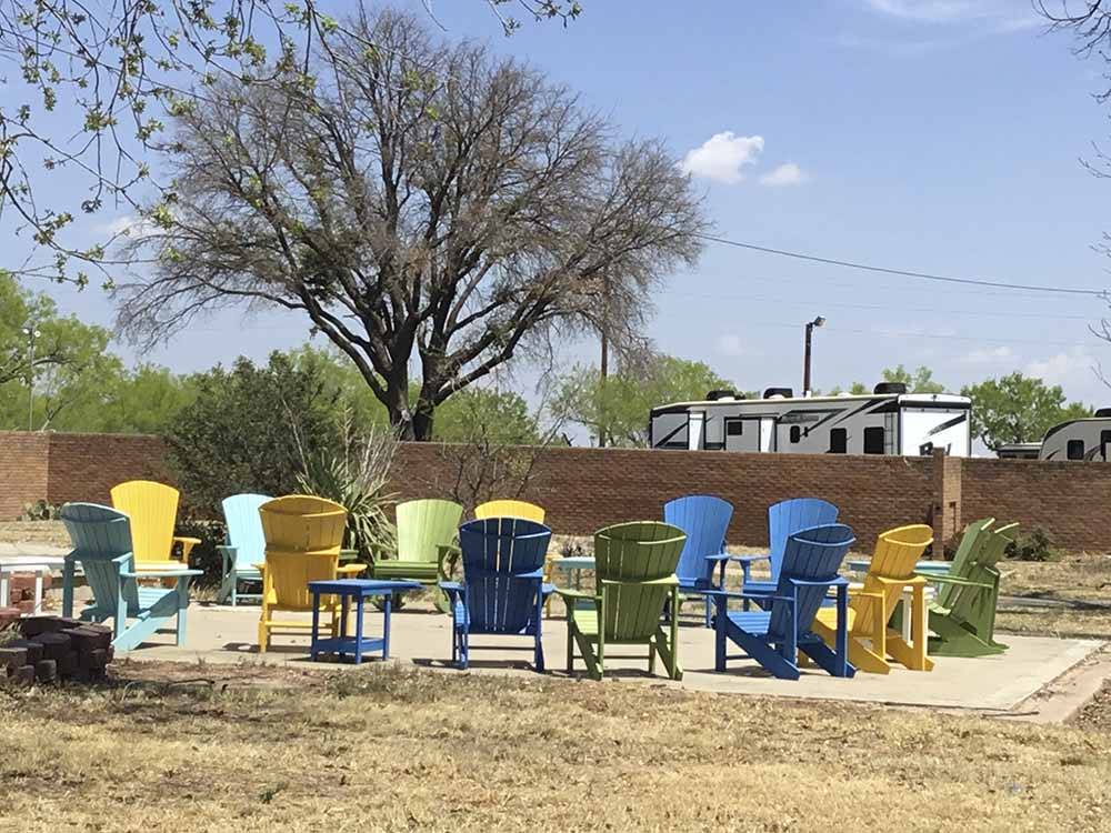 Colorful chairs around a fire pit at CONCHO PEARL RV ESTATES