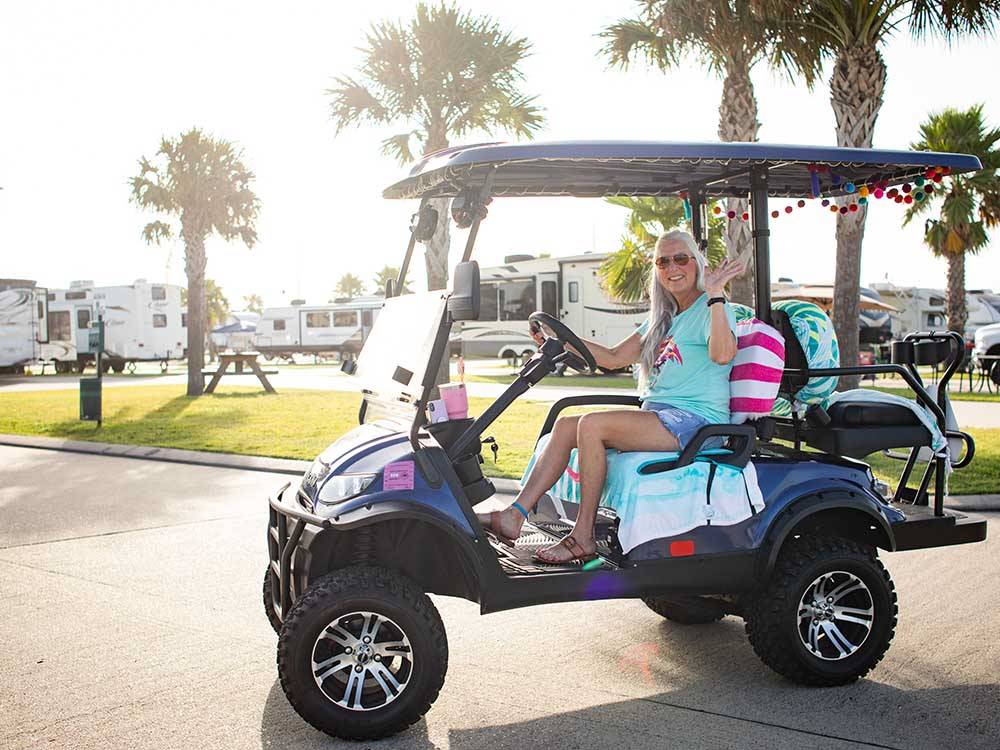 A lady driving a golf cart at STELLA MARE RV RESORT