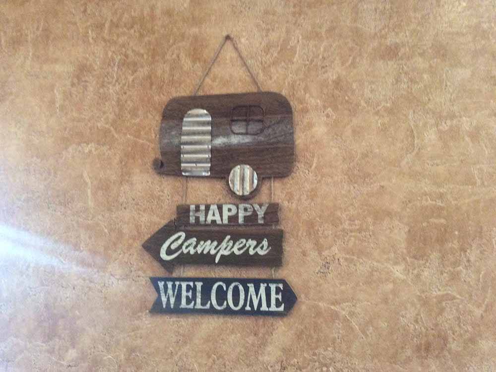 A Happy Campers Welcome sign at CRAZY HORSE RV RESORT