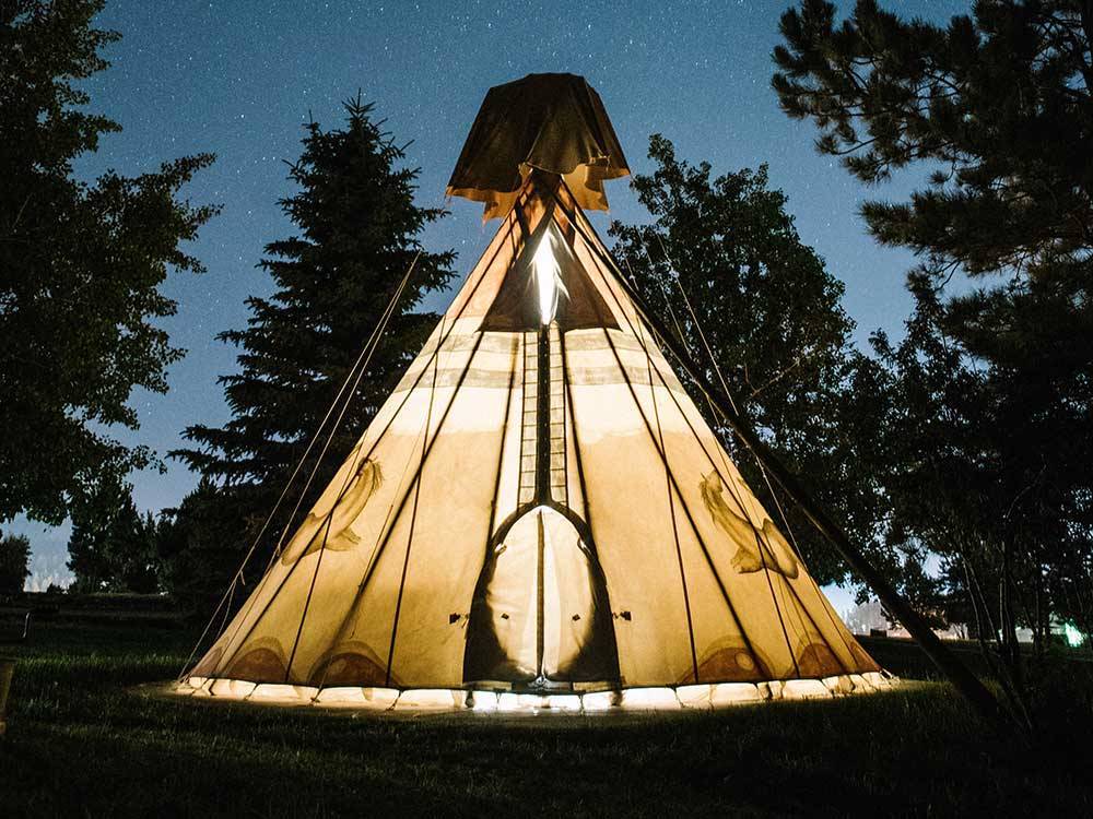 One of the teepees lit up at night at BUFFALO RIDGE CAMP RESORT