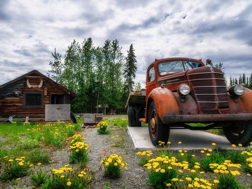 A vintage truck in front of a older cabin at RANCH HOUSE LODGE & RV CAMPING