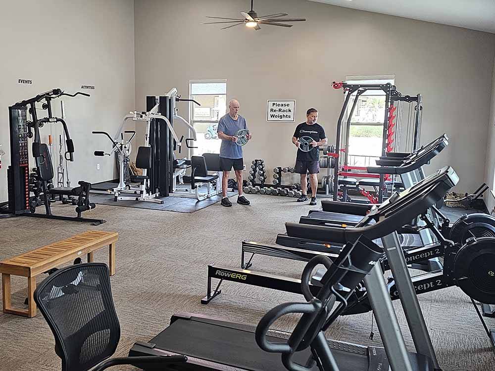 Two men holding weights in the exercise room at KEYSTONE HEIGHTS RV RESORT