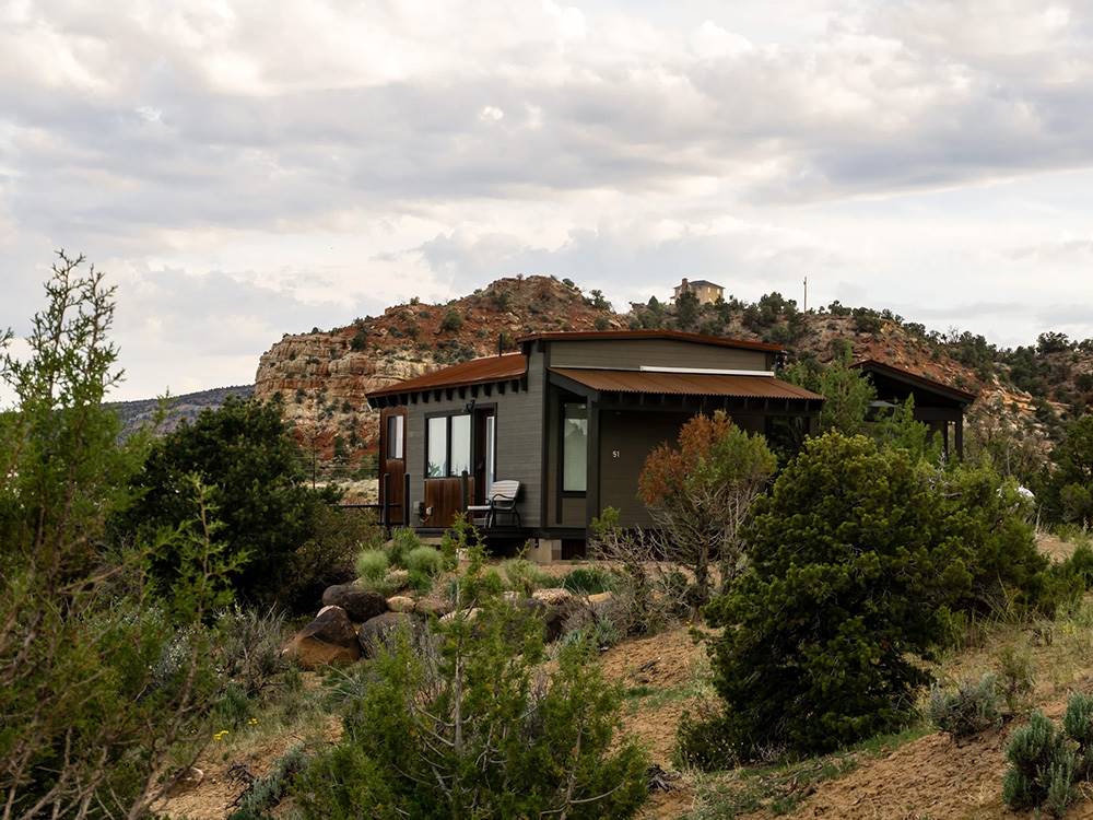 Exterior of cabin in rocky landscape with hills in the background Escalante Grand Resort