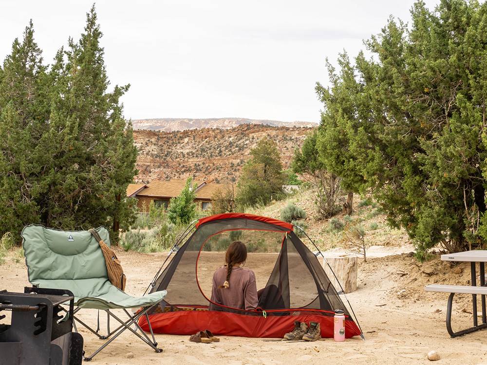 Woman relaxing in tent showing landscape view beyond at Escalante Grand Resort
