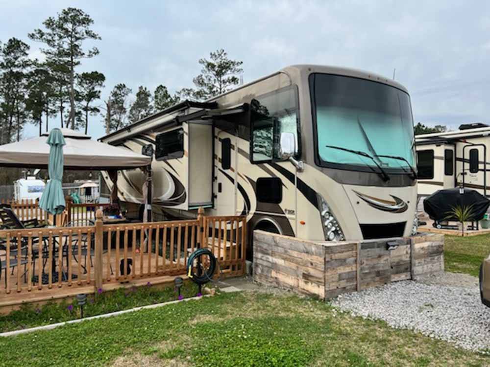 A motorhome with a fenced patio at DEEP CREEK RV RESORT & CAMPGROUND