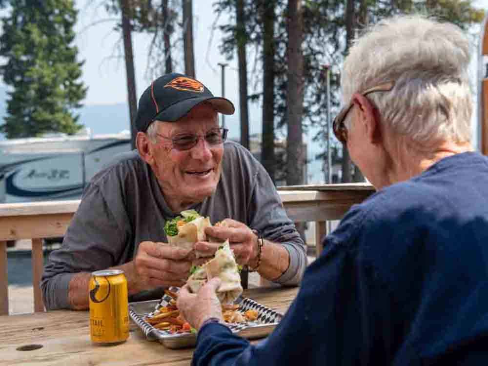A couple eating food at a picnic table at SHELTER COVE RESORT AND MARINA