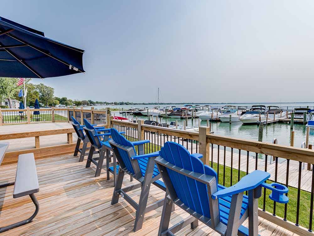 Blue chairs on a deck overlooking the marina at NORTHPOINTE SHORES RV RESORT