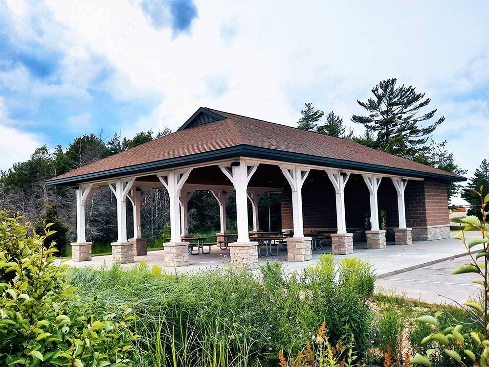 The pavilion with picnic tables at MANISTIQUE LAKESHORE CAMPGROUND