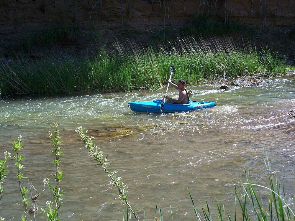 A person kayaking down the river at RAIN SPIRIT RV RESORT