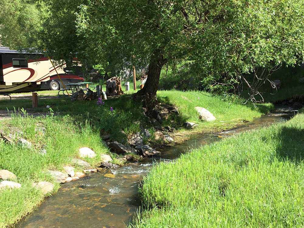 RV site next to stream at RUSHMORE VIEW RV PARK