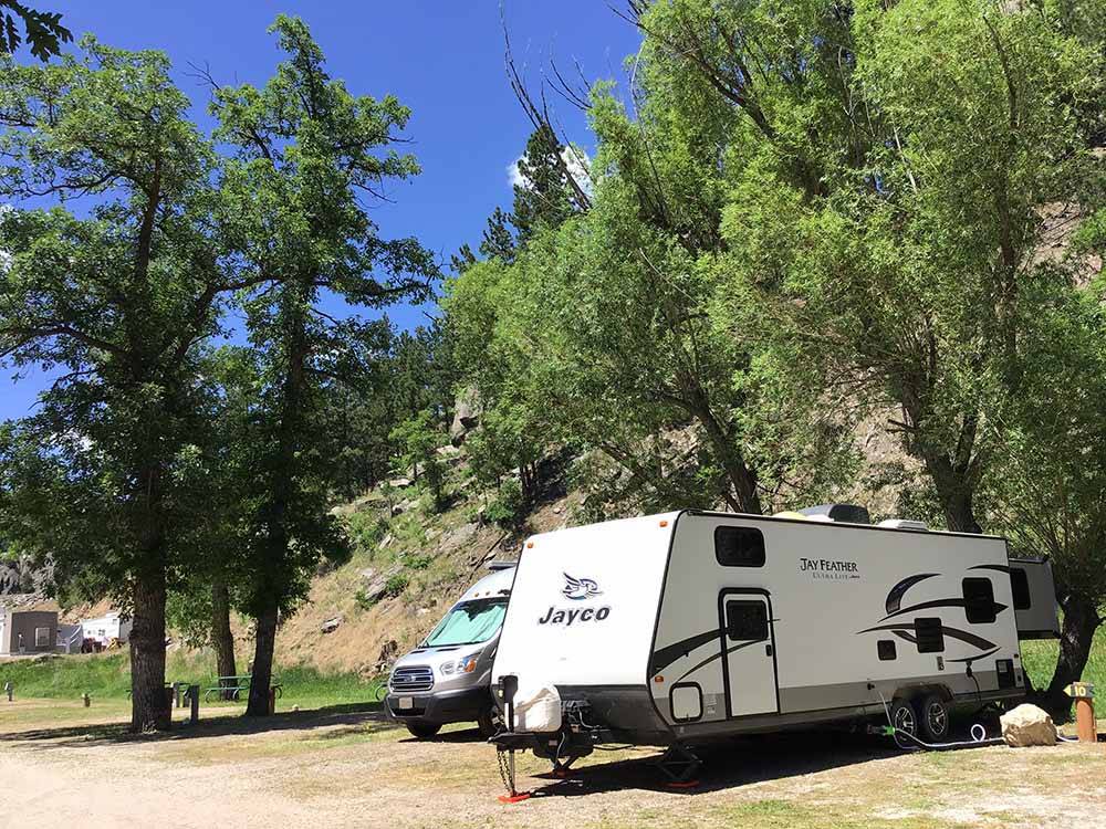 A travel trailer backed into a campsite at RUSHMORE VIEW RV PARK