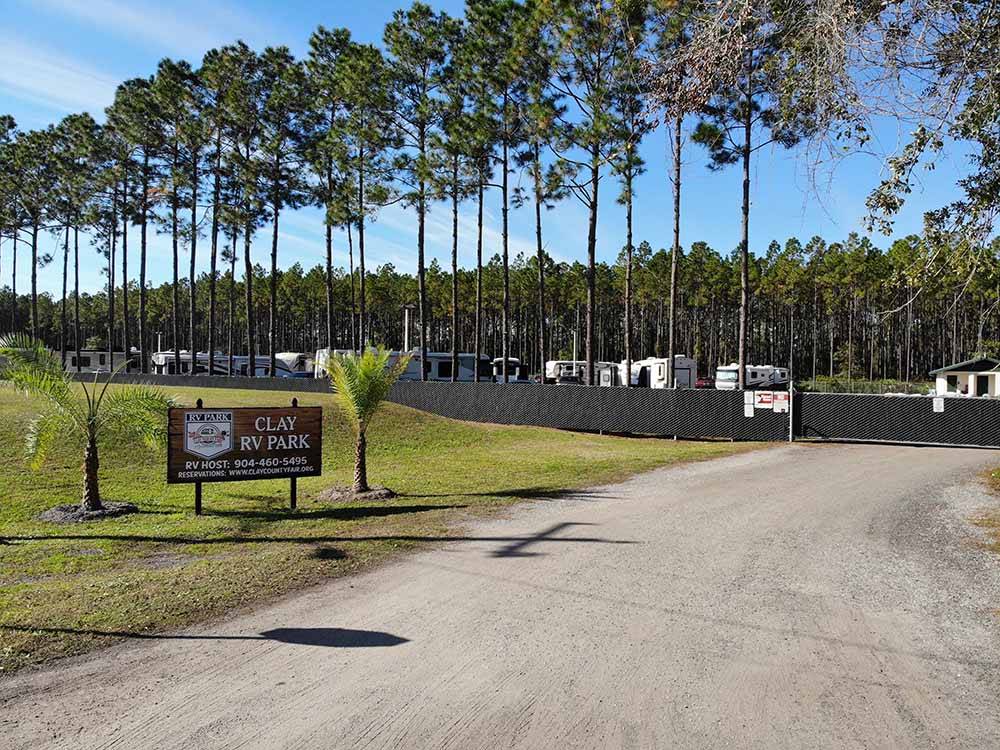 Welcome sign with trees and RVs in background at CLAY FAIR RV PARK