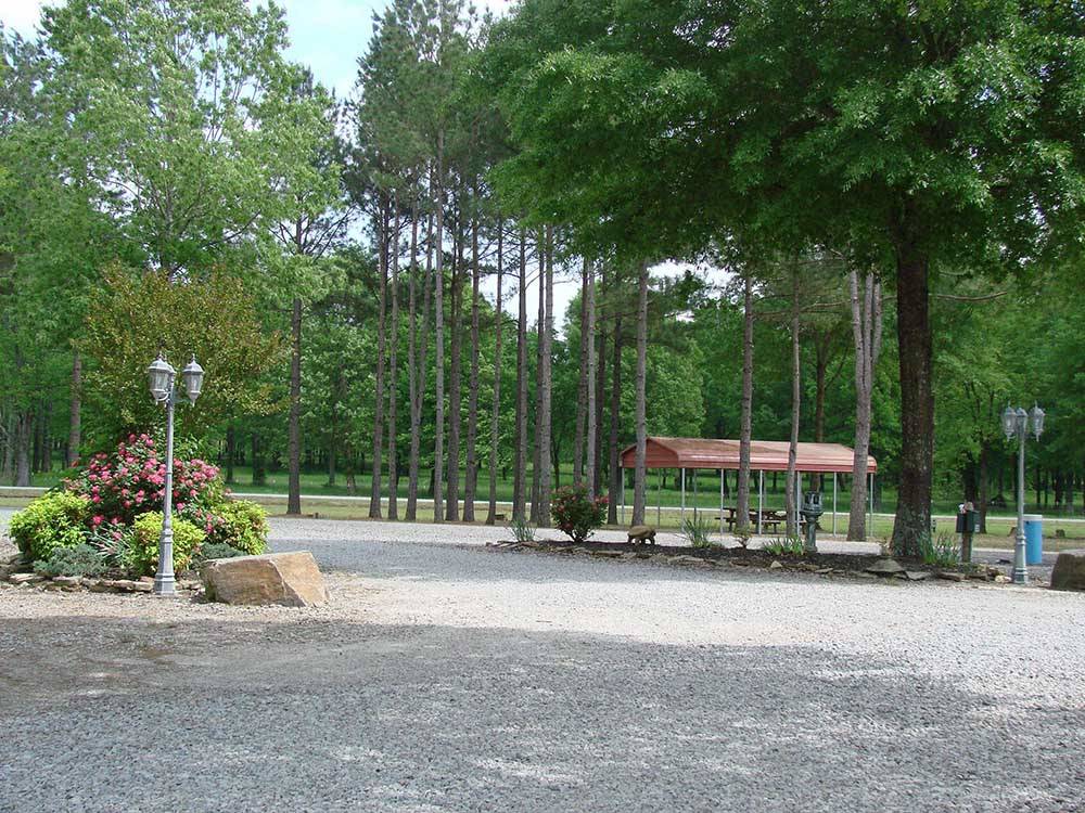 Gravel circle drive with trees and pavilion at RED RIVER RV PARK