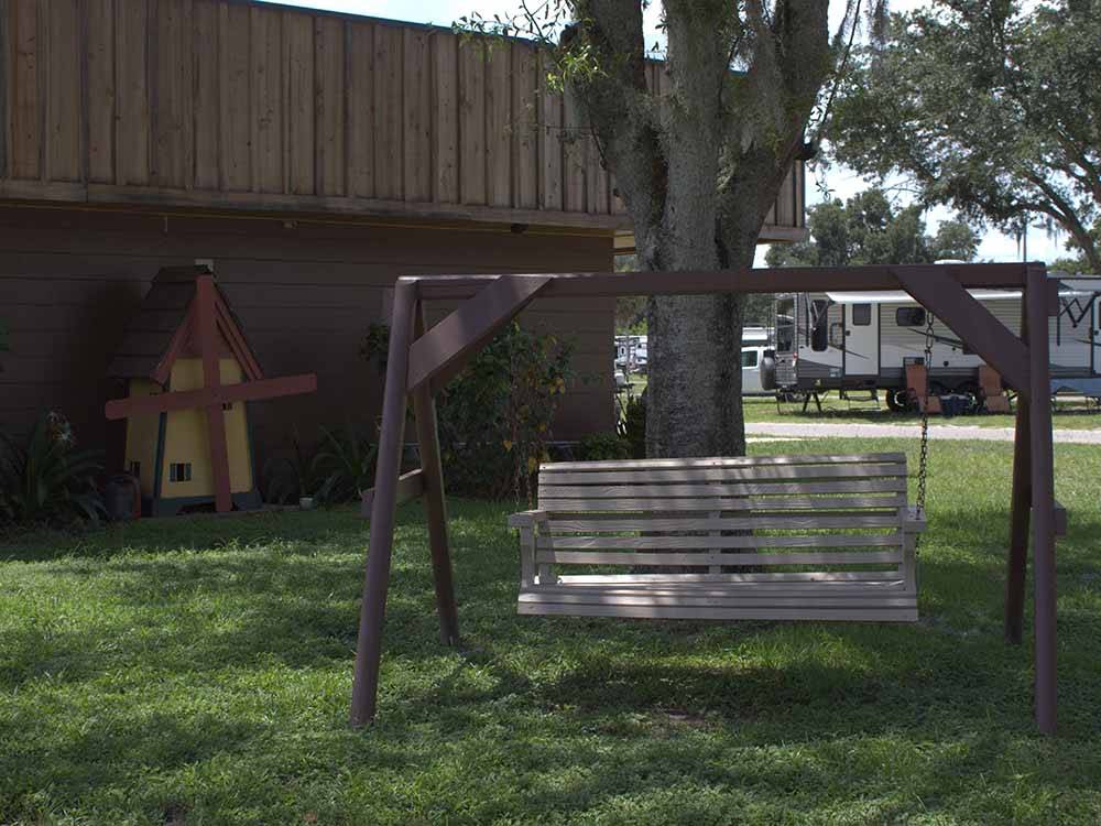 A wooded porch swing at WILDWOOD RV VILLAGE