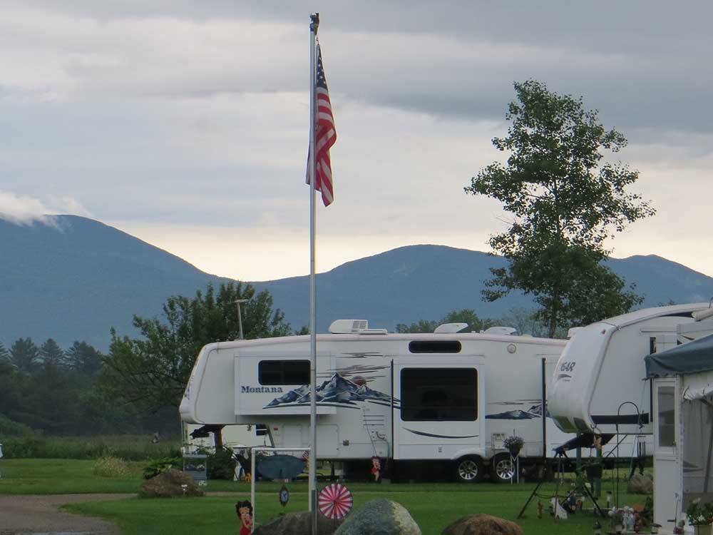 Camper in campsite with American flag at RIVERSIDE CAMPING & RV RESORT
