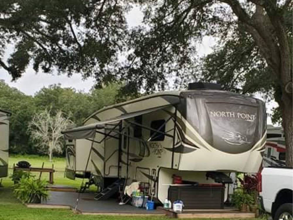A fifth wheel parked in a gravel site at BREEZY OAKS RV PARK